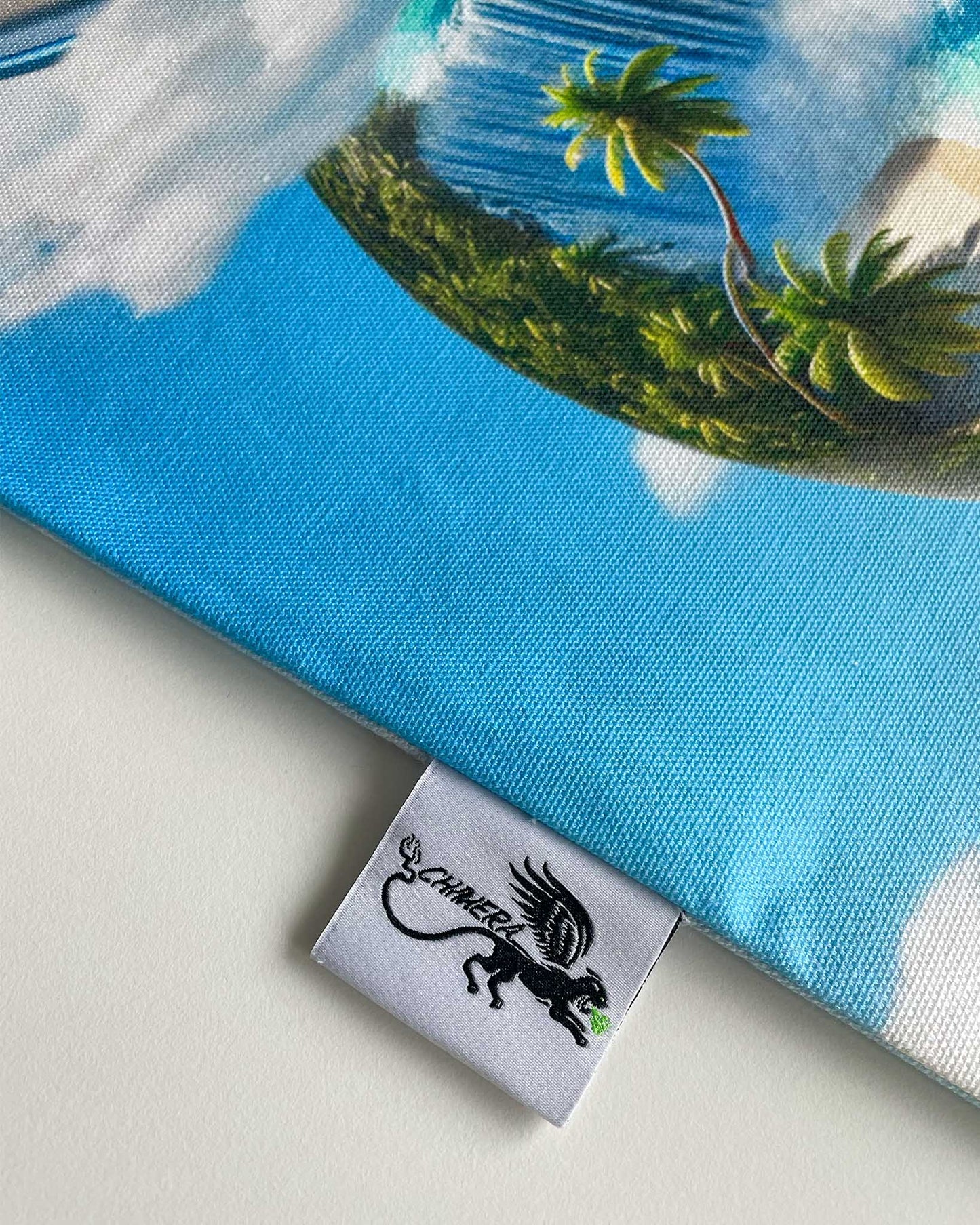 Fabric with a tropical design featuring palm trees and blue sky, branded with 'Chimera Lab'.