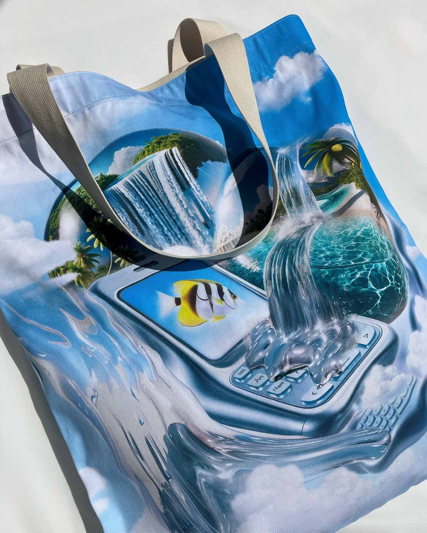 Close-up of the Dreamline OS Organic Cotton Tote showing melting mobile phone with yellow fish on the screen and beach scene in dreamy, glossy light.