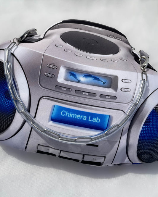 Closeup of a Y2K silver boombox handbag with digital dolphin display and detachable chain strap. Photorealistic 3D digital print inspired by early 2000s portable stereo design.