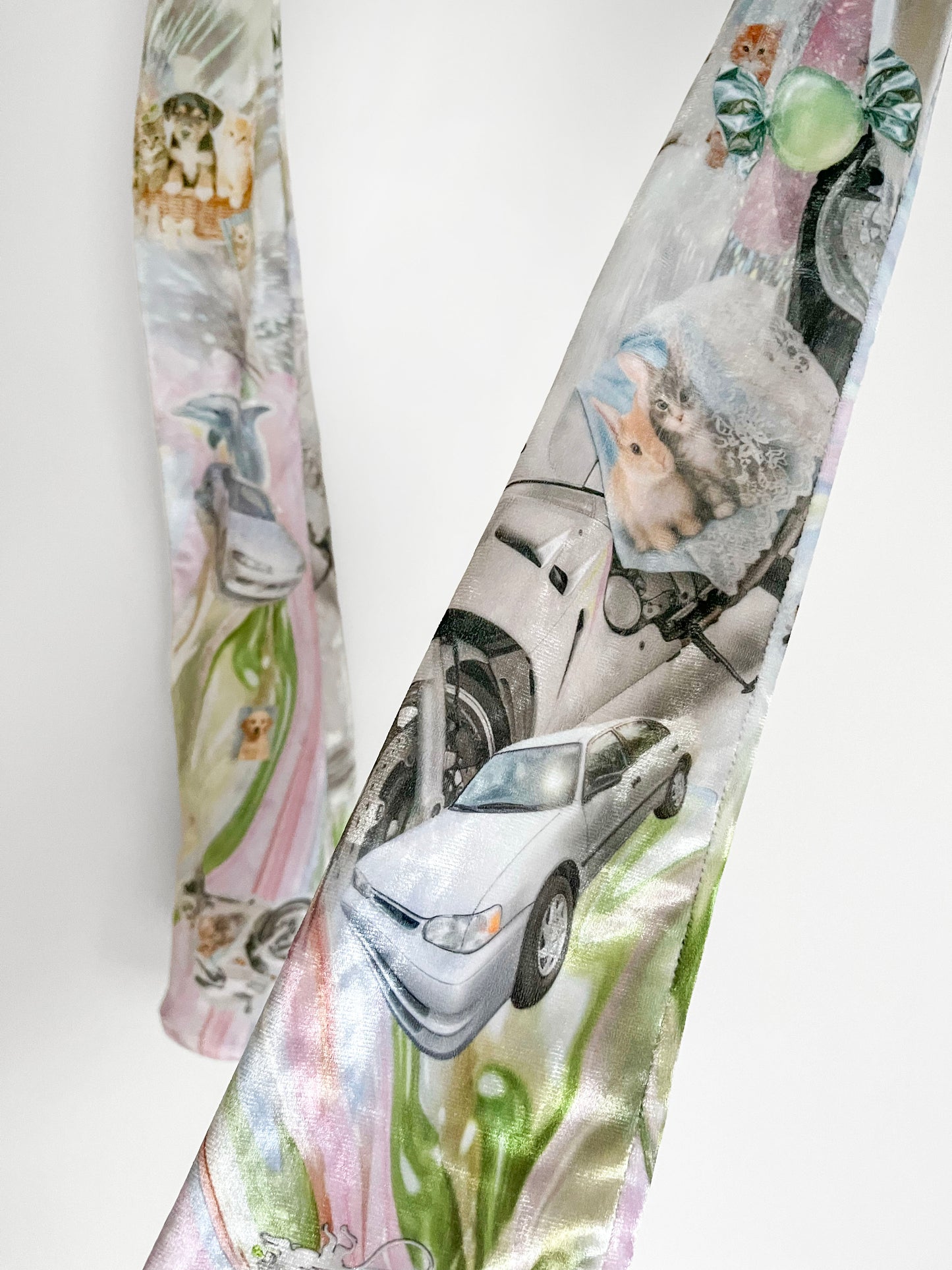 Closeup of long printed opera gloves with car and kitten print on a white background.