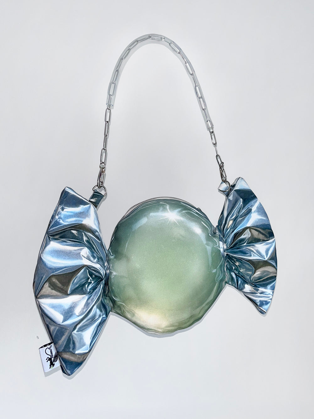 Silver candy-shaped handbag on a white background.