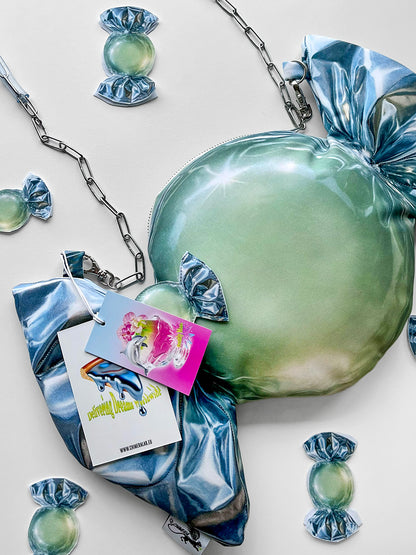 Green and metallic candy print handbag with accessories on a light background.