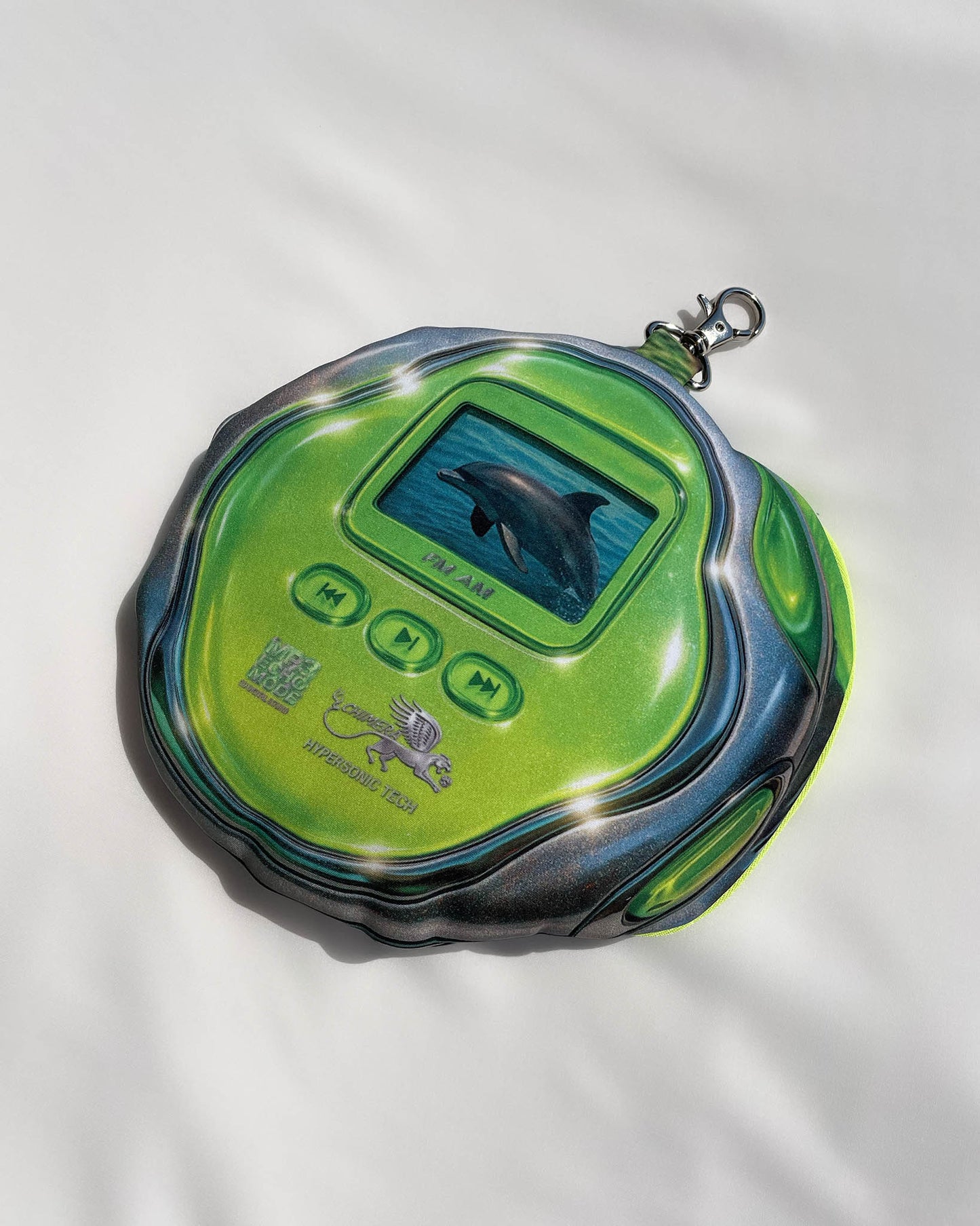 Close-up of the DOLPH MP3 pouch bag by Chimera Lab, shaped like a green retro MP3 player with dolphin screen graphic, Y2K-inspired wearable art.