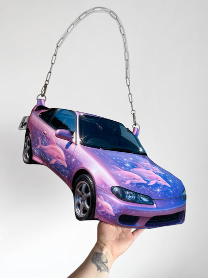 Purple and pink sports car shaped handbag with airbrushed dolphins and galaxy-style print, featuring a chain shoulder strap, by CHIMERA.
