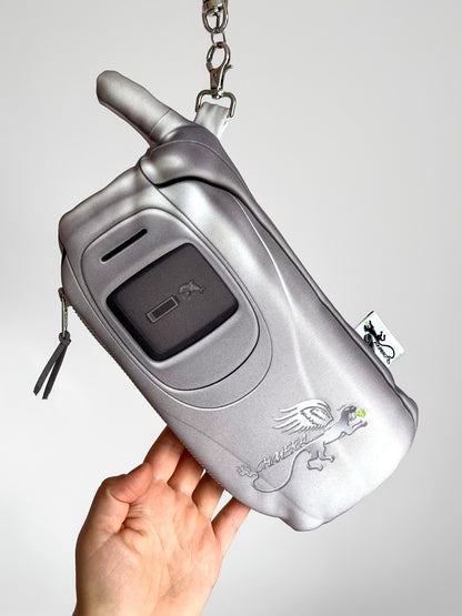 Y2K flip phone mini handbag in metallic silver with chain strap.
