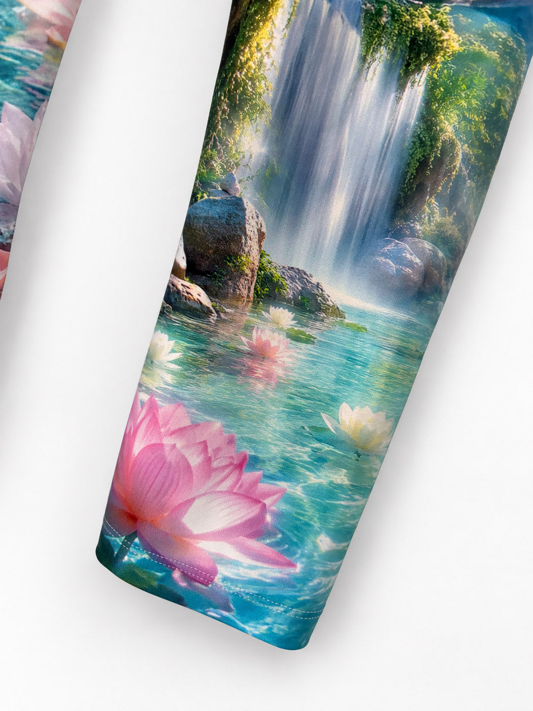 Close-up of the Zen Capri leg and hem with turquoise water, waterfall and pink lotus print.