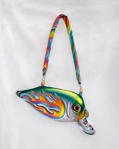 Full view of the Moto Fish Bag with a flame-wrapped chrome fish design and twisted handle, photographed on a clean white background.