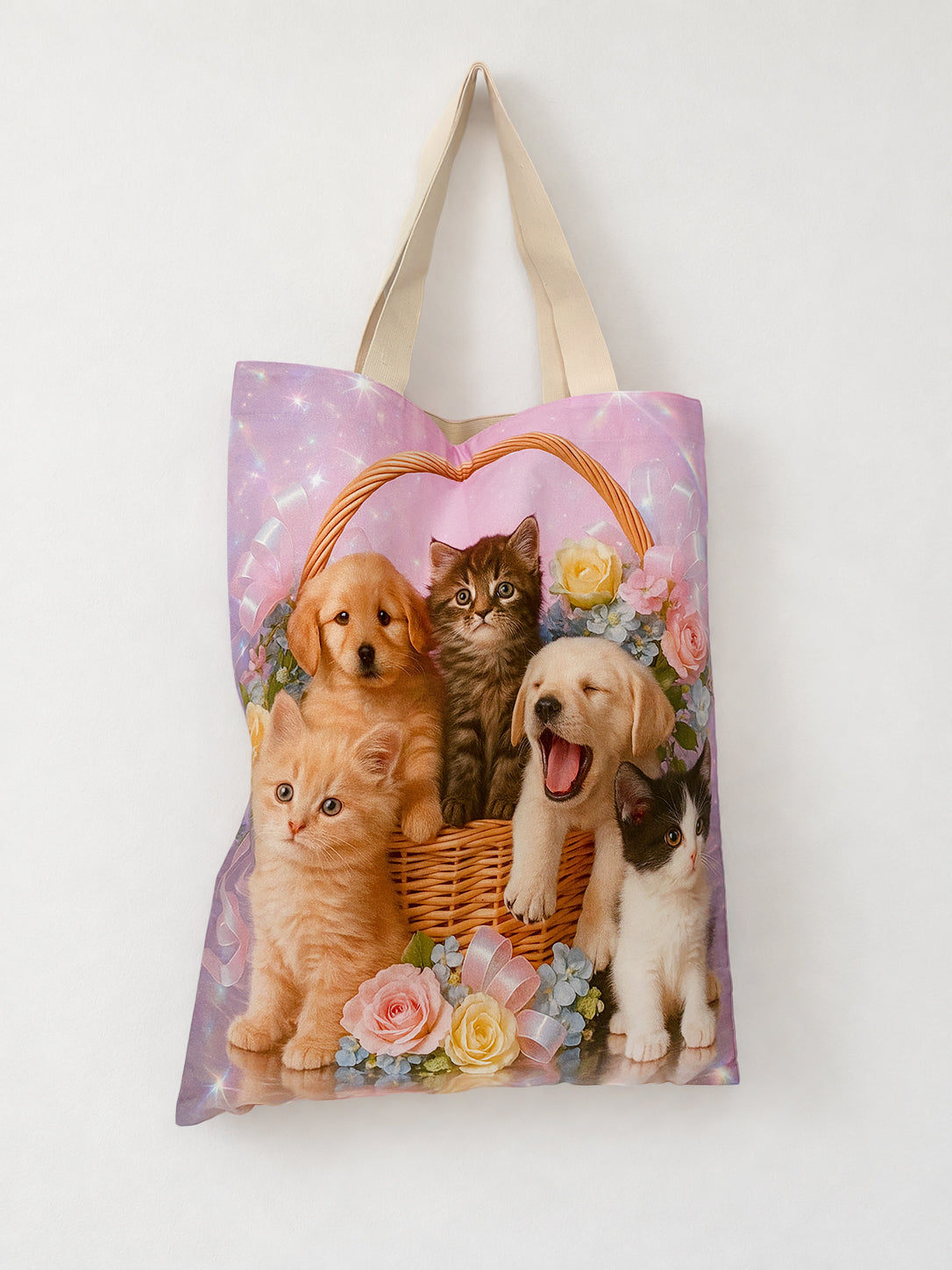 Pet Calendar Tote Bag by Chimera Lab hanging on a wall, showing kittens and puppies in a wicker basket, roses, pink ribbons and natural cotton handles.