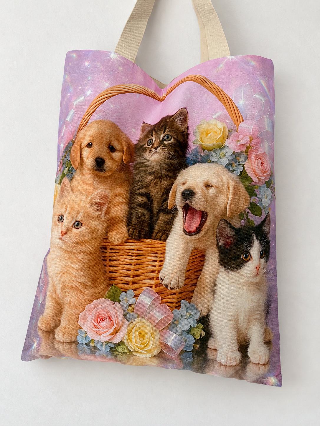 Close-up of the Pet Calendar Tote Bag print, showing kittens, a yawning puppy, roses and a wicker basket against a pink background.