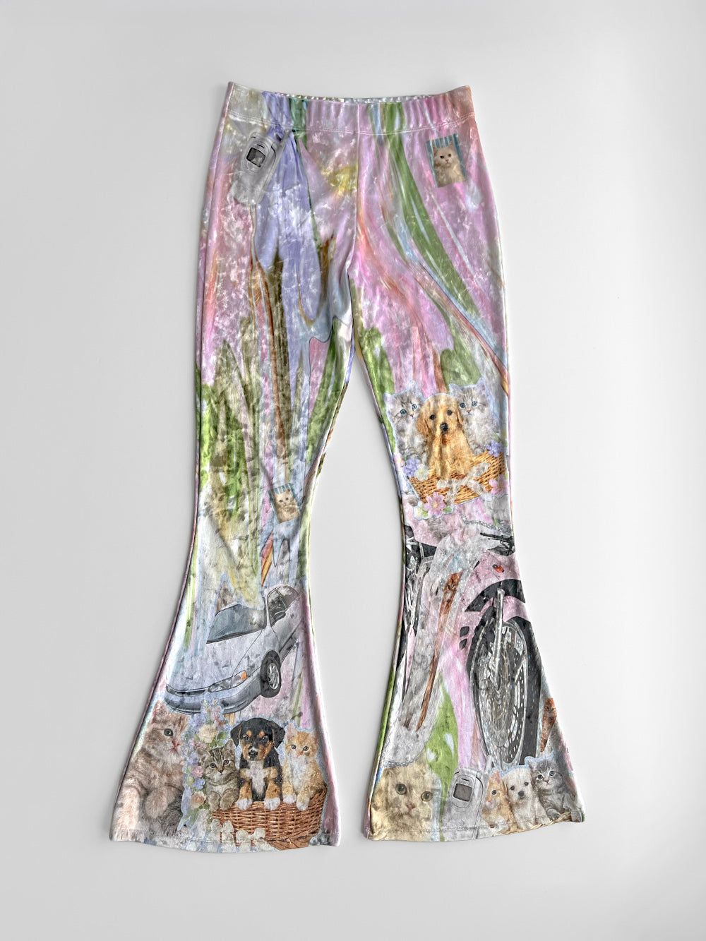Colorful flared stretchy pants with car, dolphin, puppy Y2K style sticker print on a white background.