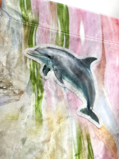 Dolphin sticker print design on a colorful fabric background.