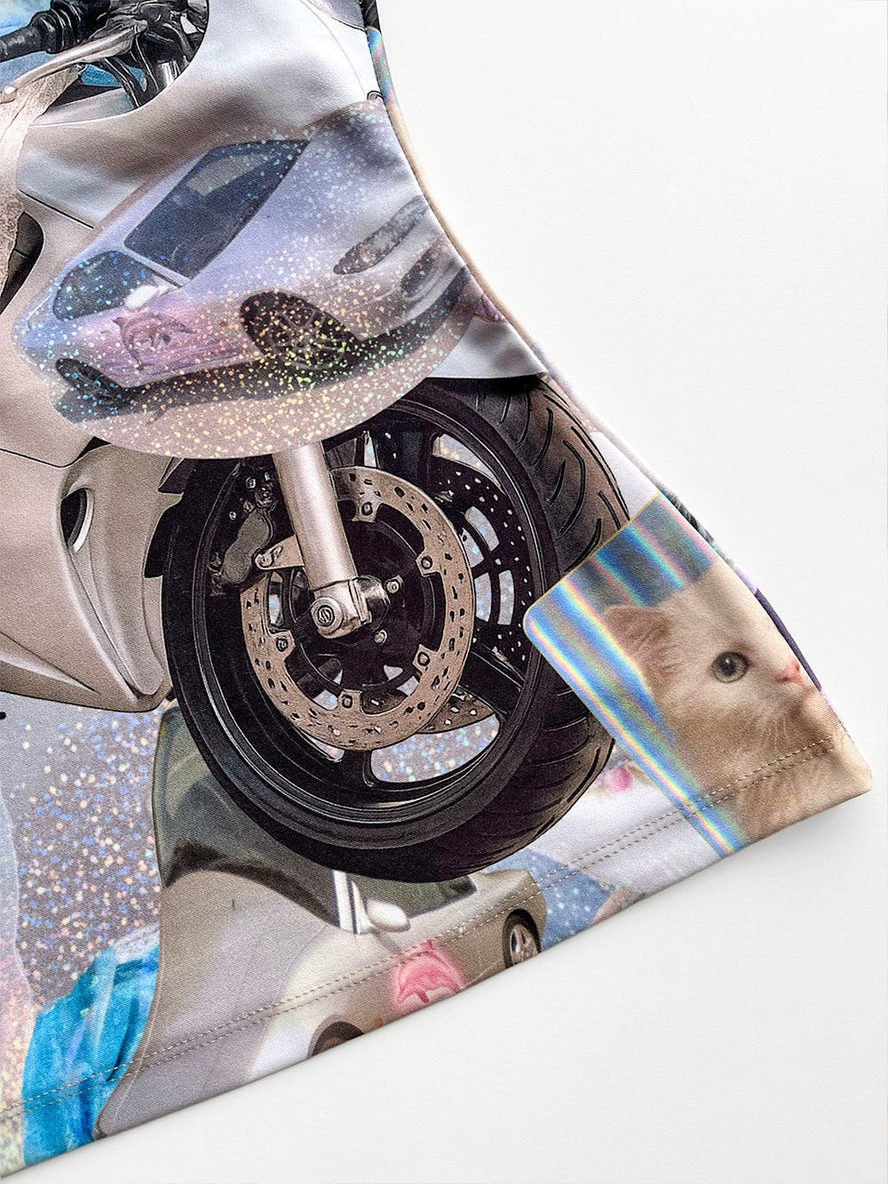 Close-up of a motorcycle wheel with a cat-themed print on a tank top.