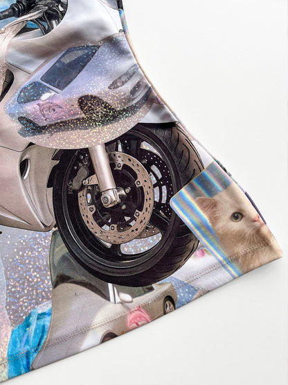 Close-up of a motorcycle wheel with a cat-themed print on a tank top.