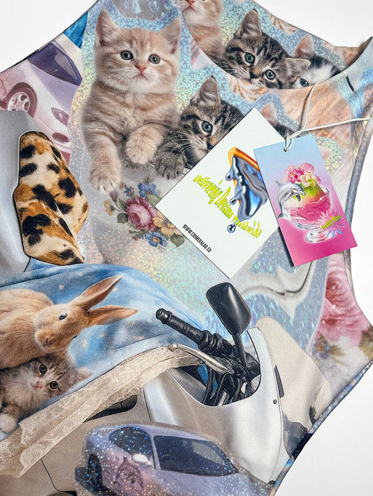 Close-up of a tank top featuring a motorcycle print with cute cats and bunnies, and two small CHIMERA brand tags.