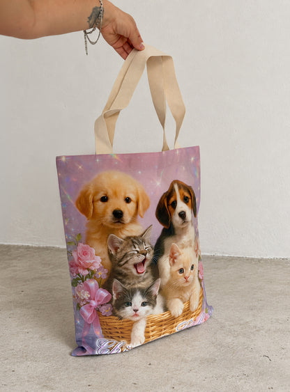 Pet Calendar Tote Bag held by its natural cotton handles, showing the oversized shape and kitten and puppy print.